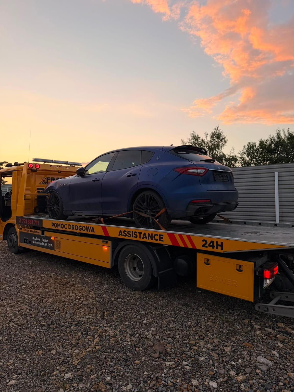 Transport Maserati Levante na lawecie na tle zachodu słońca